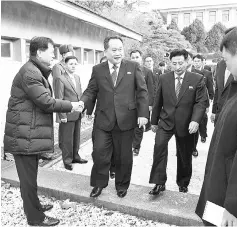  ??  ?? Ri shakes hands with a South Korean official as he crosses the concrete border to attend their meeting at the truce village of Panmunjom. — Reuters photo