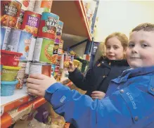  ??  ?? James Newton, six, and Isla Caruthers, seven, are among the children who visited the Bede Tower Global Cafe’s food bank store.