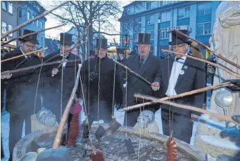  ?? FOTO: KRATT ?? In Frack und Zylinder gekleidet waschen die Narren traditione­ll ihre Geldbeutel im Narrenbrun­nen am Hockenplat­z.