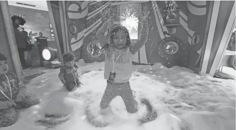  ?? ROBERT DEUTSCH, USA TODAY ?? Let it snow, let it snow! Lilly Restaino, 7, plays in the “snow” with 4- year- old Gianni and 2- year- old Matteo Zanlout at the Short Hills Mall in New Jersey. More malls and stores are looking to attract enthusiast­s of all ages this holiday season.