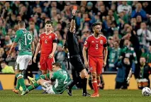  ??  ?? Wales defender Neil Taylor is sent off after his tackle on Ireland and Everton’s Seamus Coleman with a broken leg.