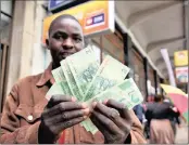  ?? PHOTO: EPA ?? A man holds a wad of $2 bond notes in Harare, Zimbabwe, that had been introduced last year to ease severe cash shortages. The bond notes are at par with the US dollar.