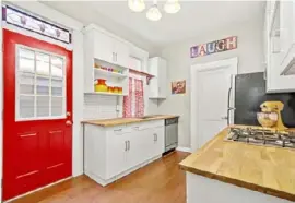  ?? Captured Listings ?? A red back door and stained-glass transom add color to the kitchen.
Editor: