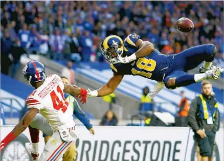  ?? Alan Crowhurst Getty Images ?? RAMS WIDE RECEIVER Kenny Britt is airborne along with the ball, which falls incomplete as Giants cornerback Dominique Rodgers-Cromartie defends. Rodgers-Cromartie had two fourth-quarter intercepti­ons to thwart Rams threats at Twickenham Stadium.