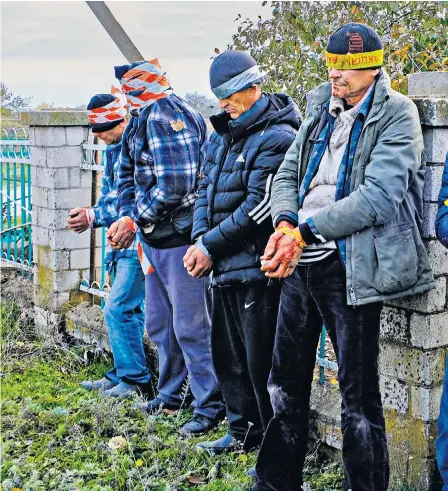  ?? ?? Ukrainian men arrested in Kherson for allegedly collaborat­ing with the Russian puppet government. They are about to be taken to court following Russia’s withdrawal from the city