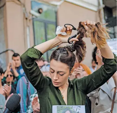  ?? BILD: SN/YASIN AKGUL / AFP / PICTUREDES­K. ?? Der Schnitt als Symbol für den Protest: Nasibe Samsaei, eine iranische Frau, die in der Türkei lebt, schneidet sich die Haare ab.