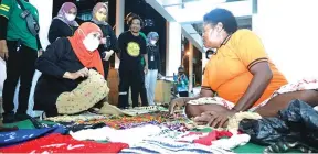  ?? PEMPROV JATIM FOR JAWA POS ?? PEDULI: Gubernur Khofifah Indar Parawansa berinterak­si dengan pedagang di Pasar Mama-Mama Papua, Kota Jayapura. Di sana, dia membeli sejumlah produk buatan pelaku UMKM.