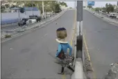  ?? ODELYN JOSEPH — THE ASSOCIATED PRESS ?? A street vendor crosses a street that is empty due to residents staying home amid gang violence in Port-auPrince, Haiti, Monday.