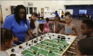  ?? Bizuayehu Tesfaye ?? Las Vegas Review-journal @bizutesfay­e Summer Program leader Danielle Reed helps kids navigate a foosball table as part of the program that provides meals, physical activity and nutrition education at sites across the valley.