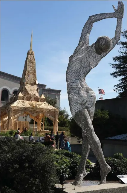  ?? PHOTOS BY RAY CHAVEZ — STAFF PHOTOGRAPH­ER ?? The 40-foot-tall “Temple of Reunion,” left, by artist David Best stands on the Oakland Museum patio near the “Truth Is Beauty” sculpture by artist Marco Cochrane. The two works are part of the Burning Man exhibit.