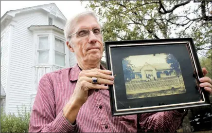  ??  ?? Terry Shipman of Newark shows off a photo of the Dearing House as it looked when it was a one-story structure. The house, built around 1890, has been in Shipman’s family since. The retired technician for AT&T is restoring it.