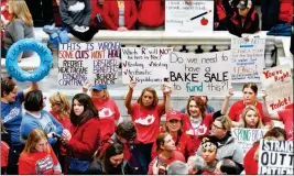  ?? ASSOCIATED PRESS ?? TEACHERS FROM ACROSS KENTUCKY HOLD UP SIGNS as they fill the state Capitol to rally for increased funding and to protest last minute changes to their state funded pension system Monday in Frankfort, Ky.