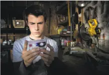  ?? Beth Dubber / Netflix ?? Dylan Minnette plays high schooler Clay Jensen, whose friend Hannah made tapes explaining her suicide.