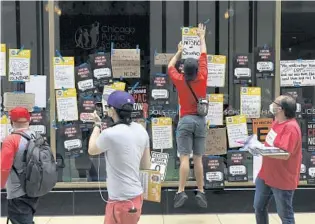  ?? ABEL URIBE/CHICAGO TRIBUNE ?? Chicago students and CTU members hang messages on the front window of CPS headquarte­rs while protesting cops in schools during a march on June 24.