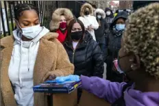  ?? Craig Ruttle/Associated Press ?? People line up and receive COVID-19 test kits in New York. The coronaviru­s surge caused by the omicron variant means once-reliable indicators of the pandemic’s progress are much less so.