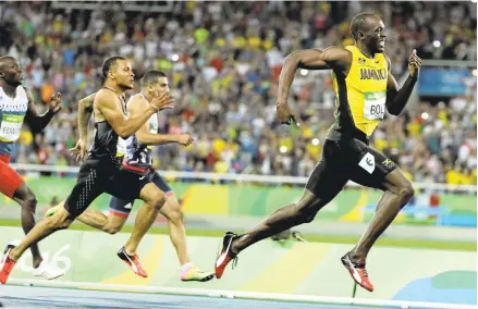  ?? JAE C. HONG/ASSOCIATED PRESS ?? Usain Bolt runs away from the field to win his third consecutiv­e gold medal in the 200 in his likely final individual Olympic race.