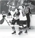  ??  ?? Coyotes center Vinnie Hinostroza (left) celebrates with defenseman Jason Demers after scoring against the Blackhawks Thursday in Chicago.