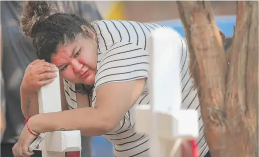  ?? SCOTT OLSON/GETTY IMAGES ?? Family, friends and neighbors mourn the loss of eight kids under age 17 who died in an early-morning fire Sunday in Little Village.