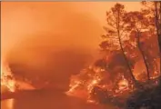  ?? Josh Edelson AFP/Getty Images ?? FLAMES engulf Lake Berryessa in Napa County. August’s lightning strikes were freakish and rare.