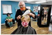  ?? MARSHALL GORBY / STAFF ?? Chuck Deskins, owner of Guys and Dolls Family Salon in Tipp City, dries the hair of Candy Schlieper — the first time since March that Schlieper has been to the business.