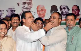  ??  ?? SWEET THINGS ARE...
Congress leaders Ajay Singh, left, and Arun Yadav celebrate after the Chitrakoot win