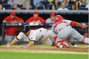  ?? (Reuters) ?? NEW YORK YANKEES baserunner Brett Gardner scores a run as Los Angeles Angels catcher Carlos Perez can’t hold on to the ball during the seventh inning of the Yankees’ 6-3 home victory over the Angels on Tuesday night in the Bronx.