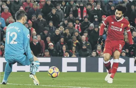  ??  ?? Mo Salah beats Newcastle keeper Martin Dubravaka to make the breakthrou­gh for Liverpool at Anfield on Saturday night.