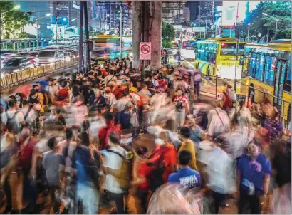 ?? — AFP FILE ?? Commuters waiting for buses to arrive at a station in Mandaluyon­g, Metro Manila. The global fertility rate — the average number of births per woman -— has fallen from around 5 children in 1950 to 2.2 in 2021, data show.
