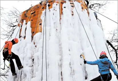  ?? FRANK VAISVILAS/DAILY SOUTHTOWN PHOTOS ?? Michelle Davis, right, and Claudia Pina climb Joel Taylor’s 32-foot ice tower recently in Monee.