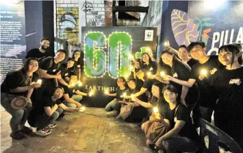  ??  ?? The artists with battery operated tea lights in front of the Earth Hour signage during the launch of Pillars of Sabah 2.0.