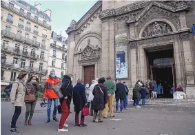  ?? MICHEL EULER/ASSOCIATED PRESS ?? Churchgoer­s line up outside the Notre-Dame-des-Champs church Sunday in Paris. French churches, mosques and synagogues were under a 30-person limit.