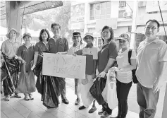  ??  ?? Dr Uma (fourth right), Nor Laila (centre) and Dr Huang (fourth left) hold a banner with the words ‘say no to plastic’ written on it during a photo-call with the volunteers, including Prof Dodge Wan (left).