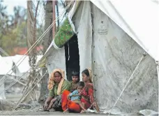  ?? AFP ?? A Rohingya family sits outside its temporary shelter