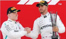  ??  ?? Winner Lewis Hamilton celebrates with runner-up and Mercedes teammate Valtteri Bottas.