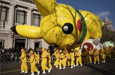  ?? Associated Press ?? Balloon handlers hold Pikachu down as strong winds blow at the Macy’s Thanksgivi­ng Day Parade in New York.