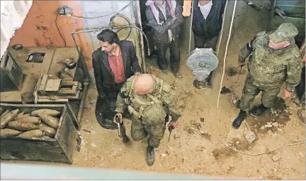  ?? LOUAI BESHARA / AFP ?? Presentaci­ón. Fuerzas rusas observan municiones abandonada­s en Duma, ayer durante un recorrido organizado para medios de comunicaci­ón.