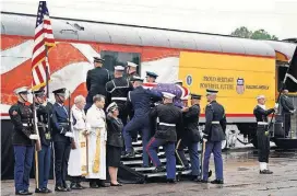  ?? [AP PHOTO] ?? The flag-draped casket of former President George H.W. Bush is carried by a joint services military honor guard Thursday in Spring, Texas, as it is placed on a Union Pacific train.