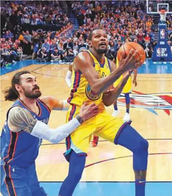  ?? AP ?? ■ Golden StateWarri­ors forward Kevin Durant ( right) goes to the basket in front of Oklahoma City Thunder centre Steven Adams during their NBA game in Oklahoma City on Tuesday.