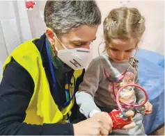 ?? (Hadassah/JTA) ?? DR. RIVKA BROOKS, director of pediatrics at Hadassah’s Mount Scopus campus, shows a young Ukrainian refugee how a stethoscop­e works. Brooks is one of Hadassah’s many doctors who volunteere­d at the organizati­on’s border clinic in Poland.
