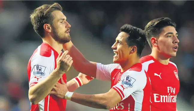  ?? GETTY ?? Alexis Sanchez (centre), who scored twice, congratula­tes Aaron Ramsey on getting Arsenal’s second goal in the 3-1 win at Hull City last night