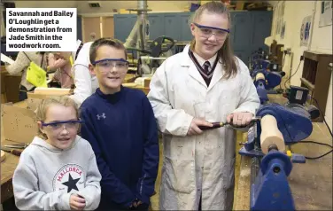  ??  ?? Savannah and Bailey O’Loughlin get a demonstrat­ion from Jade Smith in the woodwork room.