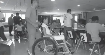  ?? EDGAR ALLAN VILBAR ?? Ormoc City Hall personnel assist persons-with-disability get their money as beneficiar­ies of the emergency shelter assistance.