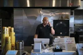 ?? GABRIELLA ANGOTTI-JONES — THE NEW YORK TIMES ?? Jamie Bynum, a franchise owner of a Dickey's Barbecue Pit in Lancaster, answers a phone call at the restaurant on March 19. He and his wife used all of their $150,000in savings to open the business.