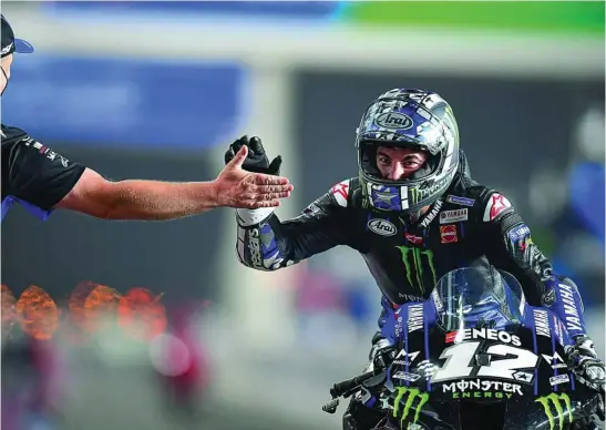  ?? EFE ?? Viñales choca la mano con un miembro de su equipo después de ganar la primera carrera de la temporada 2021