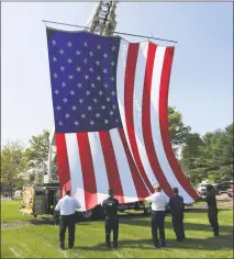  ??  ?? Officials raise the flag with a ladder truck during the military ceremony in Middletown. Lt. Gov. Nancy Wyman represente­d the state at the mid-morning observance.