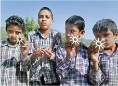  ?? — PTI ?? Boys show parts of a mortar shells fired from across the LoC by Pakistan in Panjgrain village of Rajouri district in Jammu on Thursday.