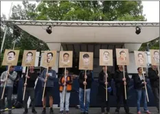  ??  ?? Demonstrat­ors hold signs with people killed NSU outside the court in Munich, southern Germany, prior to the verdict on Wednesday. TobIAs hAse/dPA VIA AP