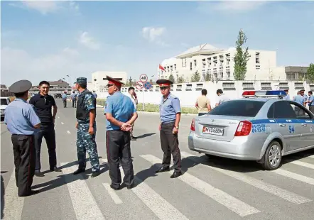 ?? Reuters ?? Terror probe: Officials gathering near the site of the bomb blast outside the Chinese embassy in Bishkek, Kyrgyzstan. —