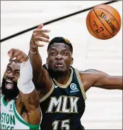  ?? AP ?? Clint Capela (three blocks, nine rebounds Wednesday) and the Celtics’ Jaylen Brown reach for the ball. Capela does good work protecting the basket but the Hawks need more from defenders playing in front of him.