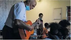  ?? ?? Music teacher Peter van Wyk and some of the children involved in Join Bands, Not Gangs in Scottsdene, Kraaifonte­in.